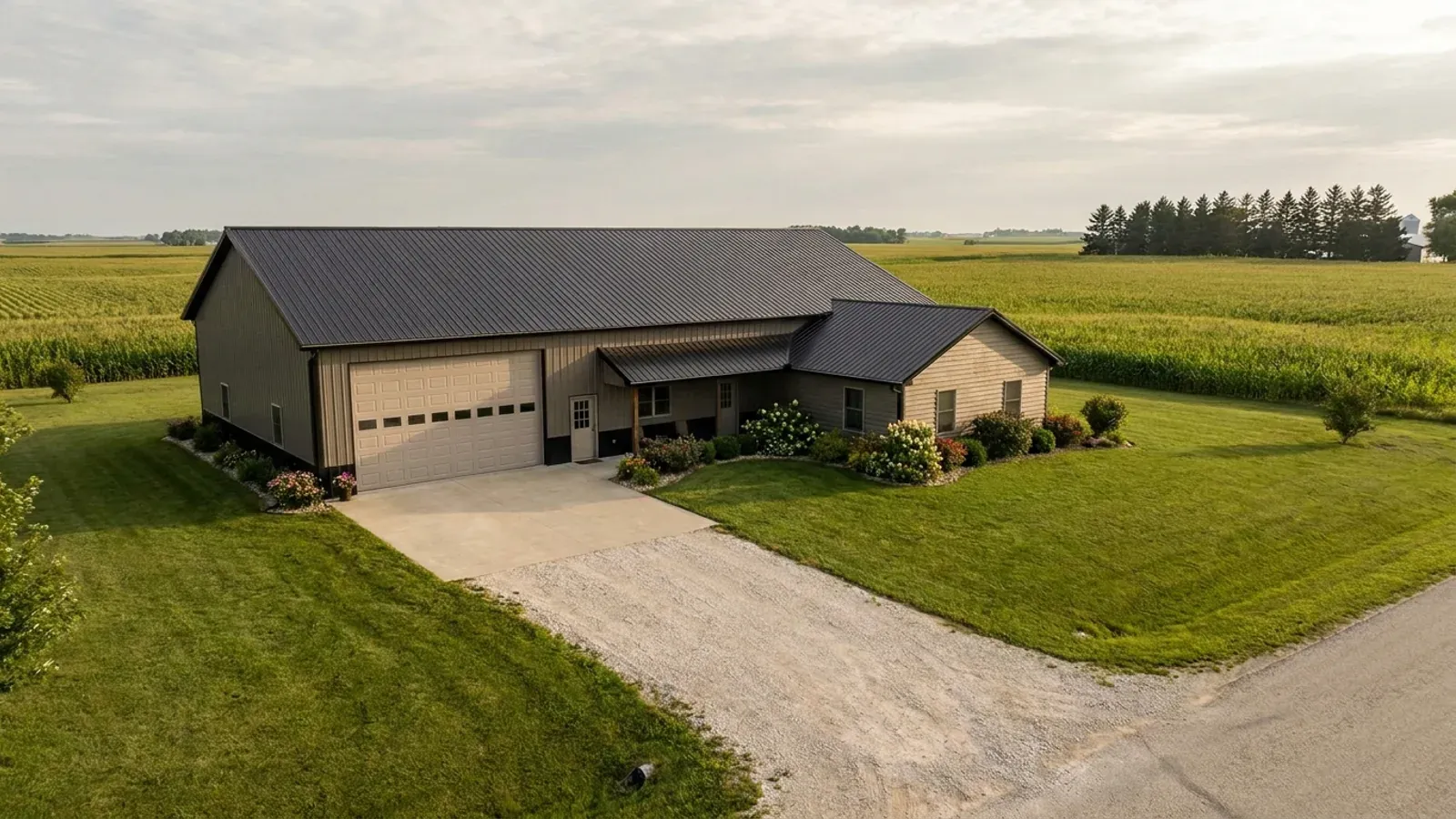 A barndominium with a large, high-eaved garage bay attached to a lower single-story living wing.